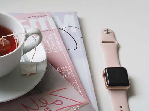 coffee cup smartwatch near three books blog